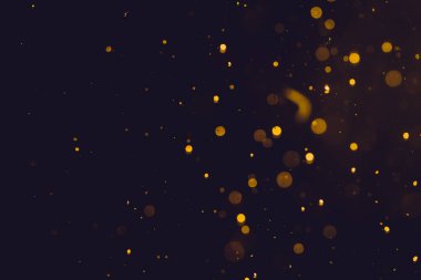 Siyah arkaplanda koyu soyut altın bokeh parıltısı