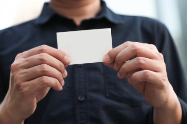 Boş beyaz kartviziti olan kendine güvenen bir iş adamı.