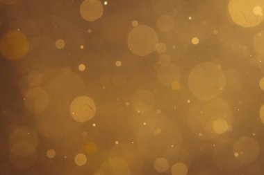 Siyah arkaplanda koyu soyut altın bokeh parıltısı
