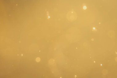 Siyah arkaplanda koyu soyut altın bokeh parıltısı