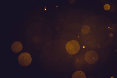Siyah arkaplanda koyu soyut altın bokeh parıltısı