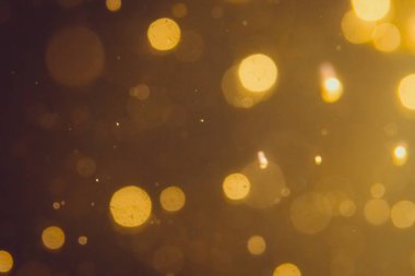 Siyah arkaplanda koyu soyut altın bokeh parıltısı