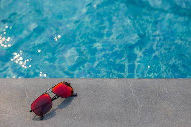 Moda güneş gözlükleri yüzme havuzu arka planında
