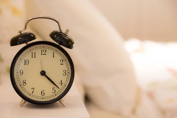 Yatağın Başucunda Bulanık Yatak Arkaplanı Olan Çalar Saat — Stok fotoğraf