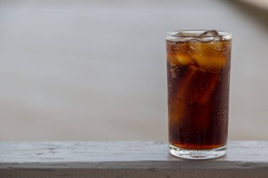 Buzlu kola, arka planda tazelenmek üzere içilmeye hazır.