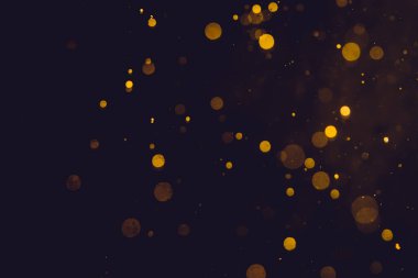 Siyah arkaplanda koyu soyut altın bokeh parıltısı