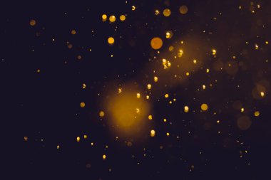 Siyah arkaplanda koyu soyut altın bokeh parıltısı