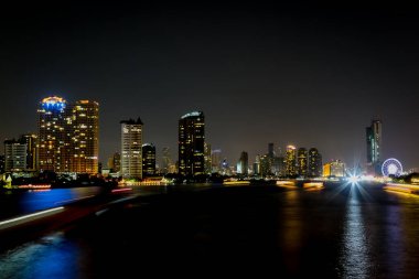 Şehir geceleri aydınlık bokeh ve su yansıması arka planıyla