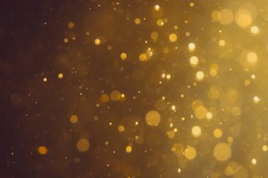 Siyah arkaplanda koyu soyut altın bokeh parıltısı