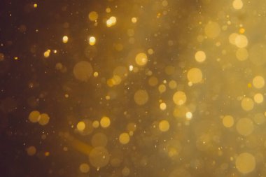 Siyah arkaplanda koyu soyut altın bokeh parıltısı