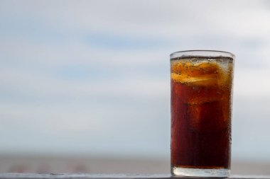 Buzlu kola, arka planda tazelenmek üzere içilmeye hazır.