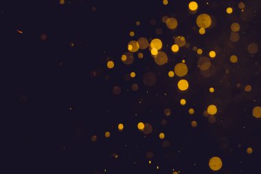 Siyah arkaplanda koyu soyut altın bokeh parıltısı