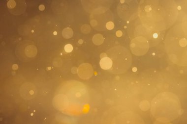 Siyah arkaplanda koyu soyut altın bokeh parıltısı