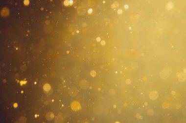 Siyah arkaplanda koyu soyut altın bokeh parıltısı