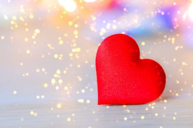 Ahşap masada yumuşak bokeh arkaplanlı kırmızı kalp şekli