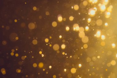 Siyah arkaplanda koyu soyut altın bokeh parıltısı