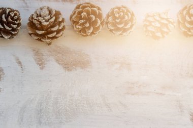 Beyaz, eski ahşap arka planda kurumuş çam topları.