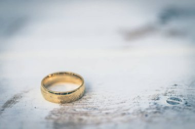 Altın yüzükler, gelin ve damadın alyansları beyaz, eski ahşap arka planda.