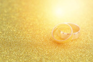 Altın yüzükler, gelin ve damadın alyansları beyaz, eski ahşap arka planda.