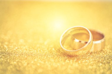 Gelinin ve damadın altın alyansları altın kaplama arka planda