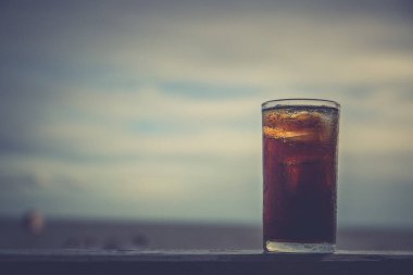 Buzlu kola, arka planda tazelenmek üzere içilmeye hazır.