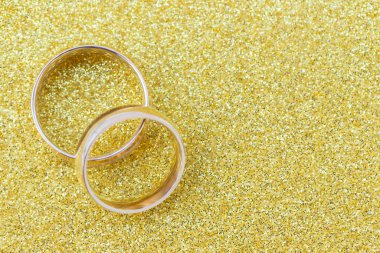 Gelinin ve damadın altın alyansları altın kaplama arka planda