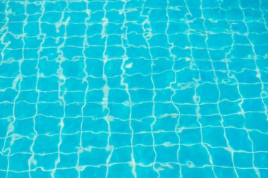 Mavi yüzme havuzunun arka planındaki sudan yansımalar.