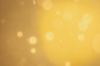 Siyah arkaplanda koyu soyut altın bokeh parıltısı