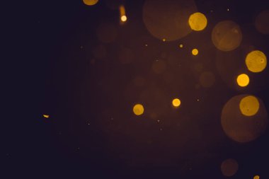 Siyah arkaplanda koyu soyut altın bokeh parıltısı