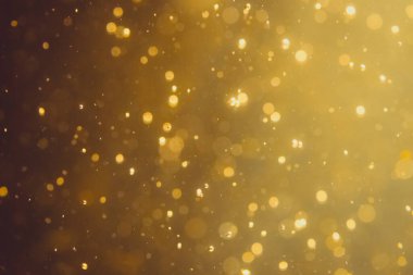 Siyah arkaplanda koyu soyut altın bokeh parıltısı
