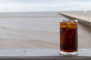 Buzlu kola, arka planda tazelenmek üzere içilmeye hazır.