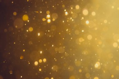 Siyah arkaplanda koyu soyut altın bokeh parıltısı