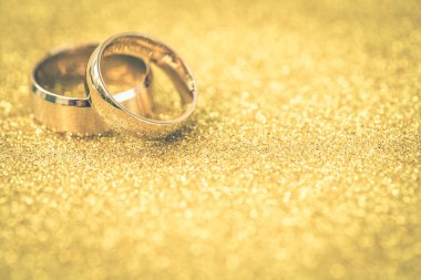 Gelinin ve damadın altın alyansları altın kaplama arka planda
