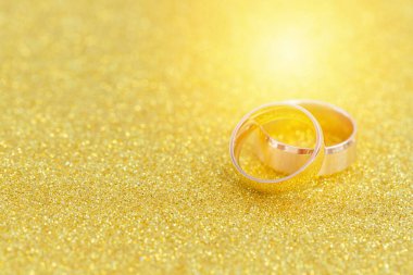 Gelinin ve damadın altın alyansları altın kaplama arka planda