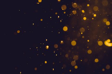 Siyah arkaplanda koyu soyut altın bokeh parıltısı