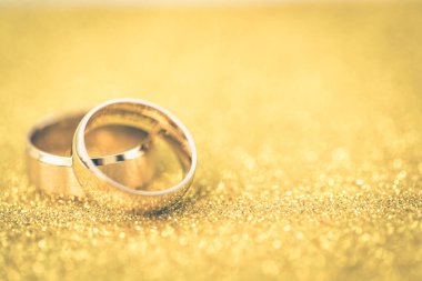 Gelinin ve damadın altın alyansları altın kaplama arka planda