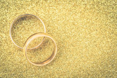 Gelinin ve damadın altın alyansları altın kaplama arka planda