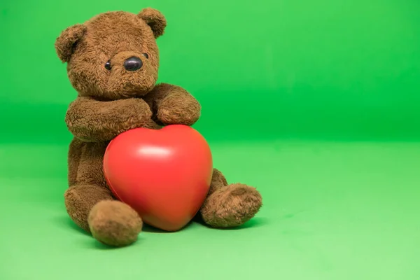 Barna Teddy Bear Tartja Piros Szív Zöld Háttérben Üres Hely — Stock Fotó