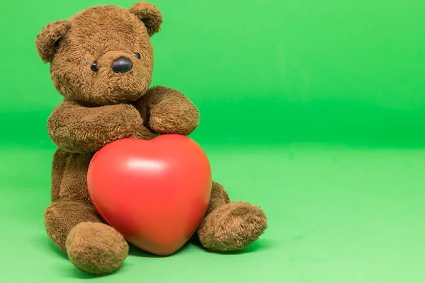 Medvídek Hnědý Drží Červené Srdce Zeleném Pozadí Prázdným Prostorem — Stock fotografie