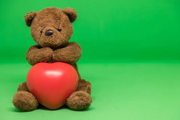 Barna Teddy Bear Tartja Piros Szív Zöld Háttérben Üres Hely — Stock Fotó