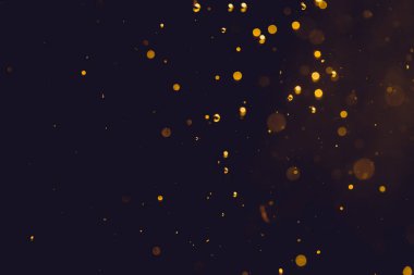 Siyah arkaplanda koyu soyut altın bokeh parıltısı