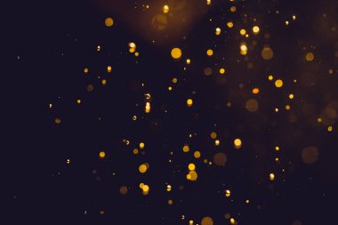 Siyah arkaplanda koyu soyut altın bokeh parıltısı