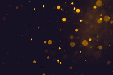 Siyah arkaplanda koyu soyut altın bokeh parıltısı