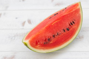 Kırmızı karpuz beyaz desenli ahşap bir zemine yerleştirilir, bol suyla birlikte meyve. Isıyı serbest bırakmaya yardımcı olur
