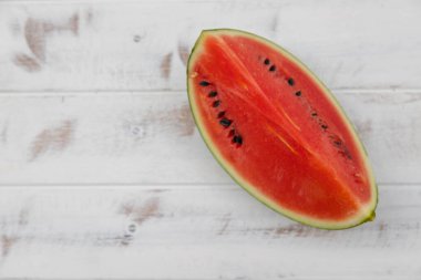 Kırmızı karpuz beyaz desenli ahşap bir zemine yerleştirilir, bol suyla birlikte meyve. Isıyı serbest bırakmaya yardımcı olur