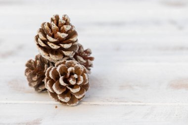 Beyaz, eski ahşap arka planda kurumuş çam topları.