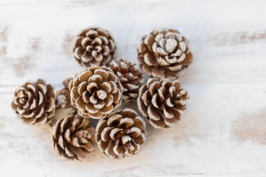 Beyaz, eski ahşap arka planda kurumuş çam topları.