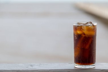 Buzlu kola, arka planda tazelenmek üzere içilmeye hazır.