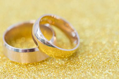 Gelinin ve damadın altın alyansları altın kaplama arka planda