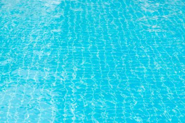 Mavi yüzme havuzunun arka planındaki sudan yansımalar.